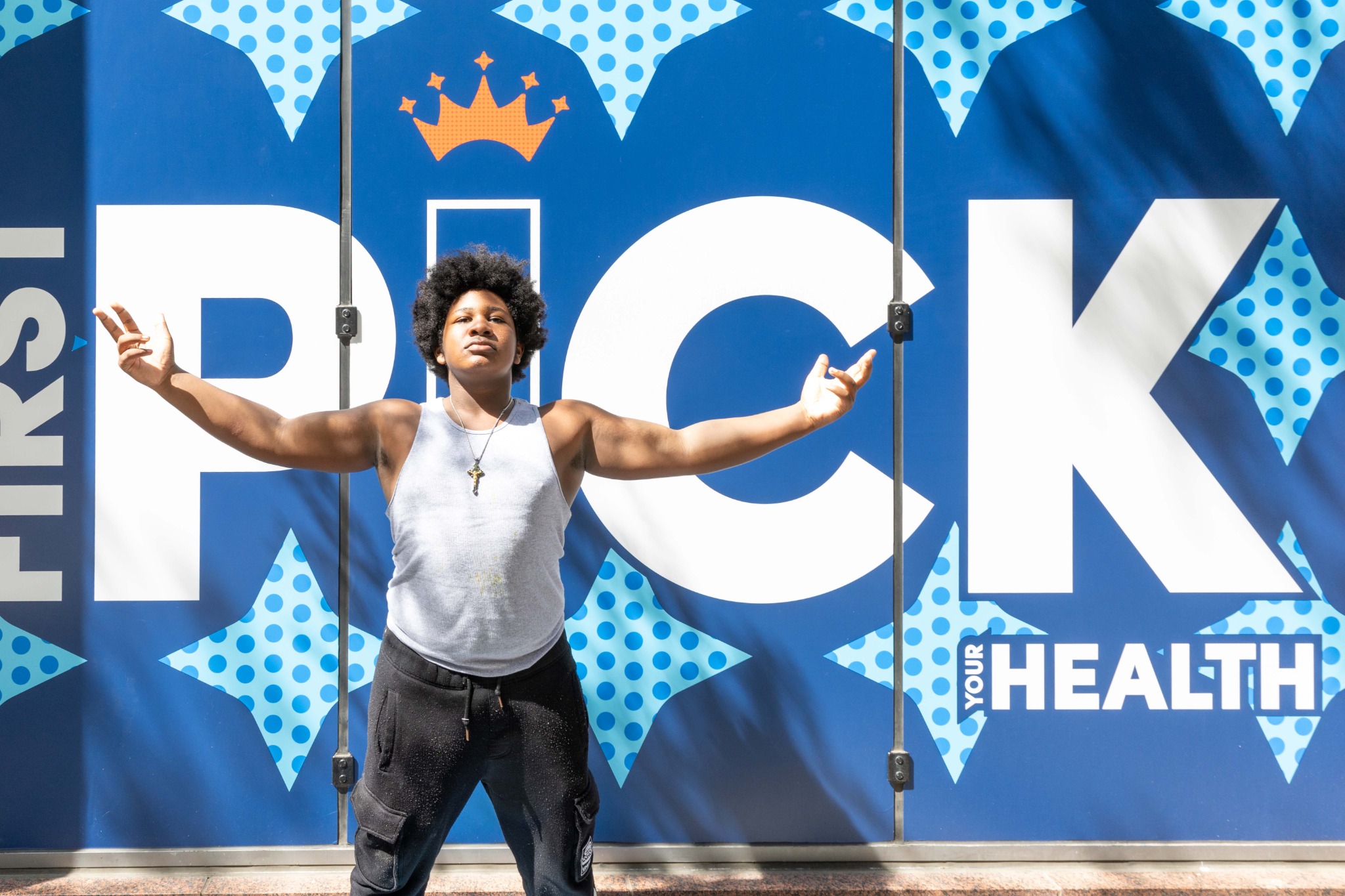Fan posing in front of the First Pick Your Health wall